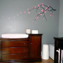 Peaceful gray and pink baby girl nursery with pink floral tree branch wall mural