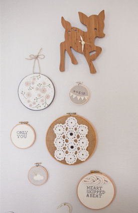 A cluster of embroidery hoops including a mini-hoop with baby's birth date arranged on the nursery walls