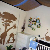 Jungle safari theme baby nursery wall mural with African trees giraffes and leaves