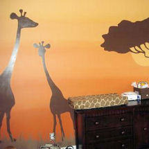 Safari jungle baby nursery theme with gold wall paint and chocolate brown giraffe and African Tree silhouette art with zebra print crib bedding and curtains