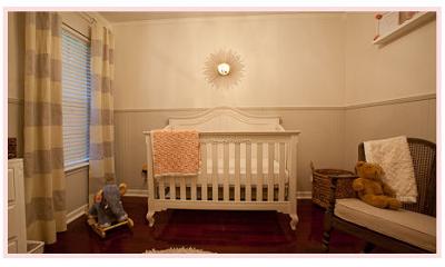 The sunburst mirror on the wall over the baby girl's crib adds a touch of metallic gold to the neutral nursery wall color. 