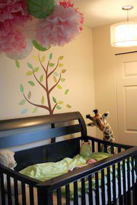 Ava's garden nursery with her giant, toy giraffe watching over our baby girl sleeping in her crib.