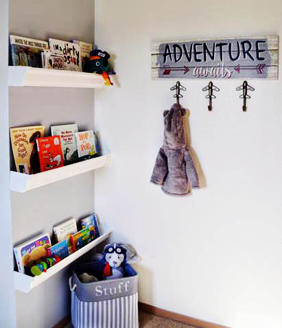 DIY rain gutter nursery wall book shelves in a baby boy nursery reading nook corner.