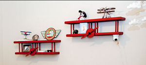 Red airplane wall shelves in a baby boy airplane nursery theme