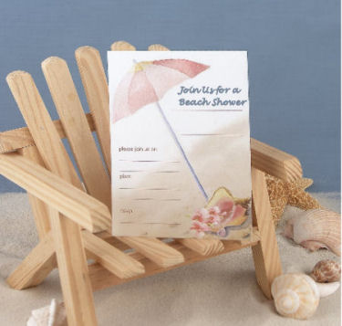 Beach theme baby shower invitation on a wooden adirondack chair in the sand surround by seashells under an umbrella by the ocean in pink and blue for baby girls or boys