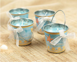 Beach theme sand buckets are candle pails decorated with ribbons and shells used as baby shower favors