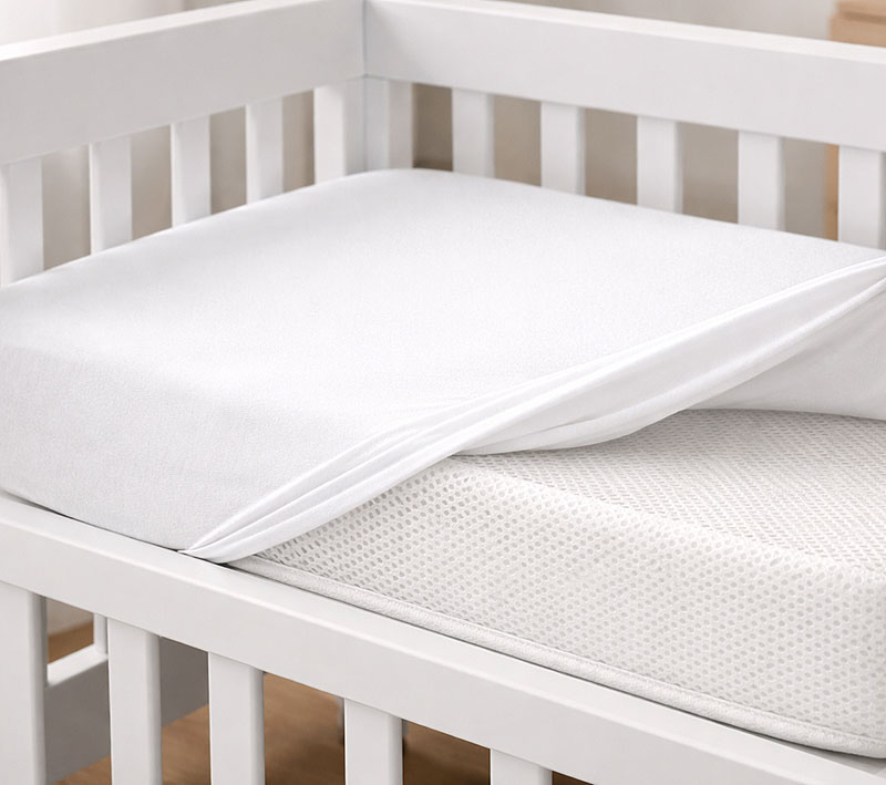 close view of breathable mini crib mattress surface inside a modern mini crib with fitted sheet