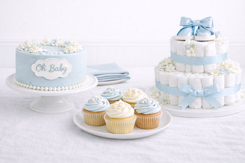Comparison of cake cupcakes and diaper cake for baby shower setup
