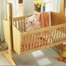 Heirloom wood pendulum baby cradle with classic lines made from ash wood