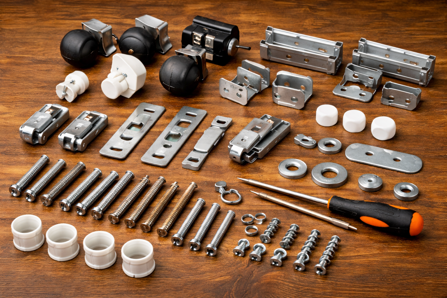 assorted crib replacement parts including caster wheels, metal brackets, connector plates, and washers arranged neatly on a tabletop