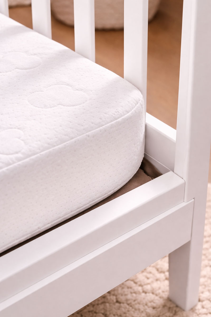 Crib corner showing small but visible mattress gap that can be overlooked