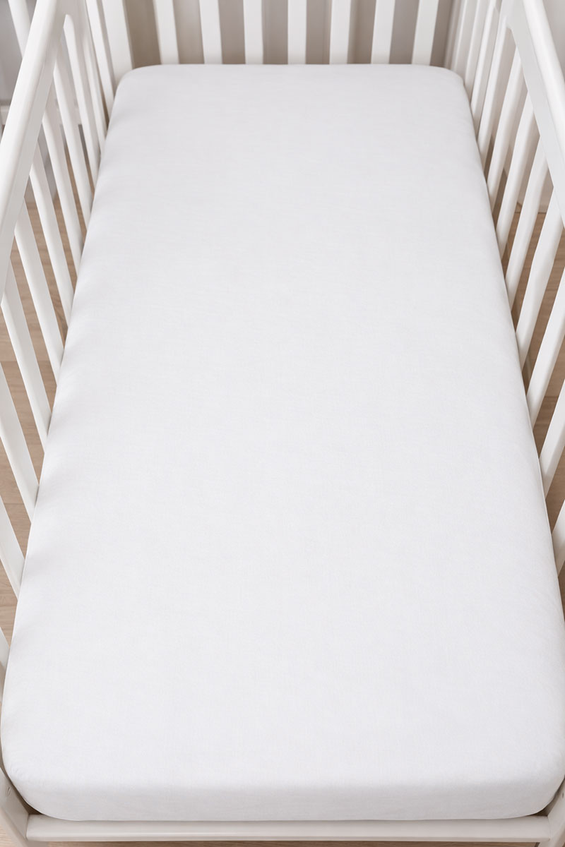Plain crib mattress with fitted sheet only and no extra padding blankets or pillows