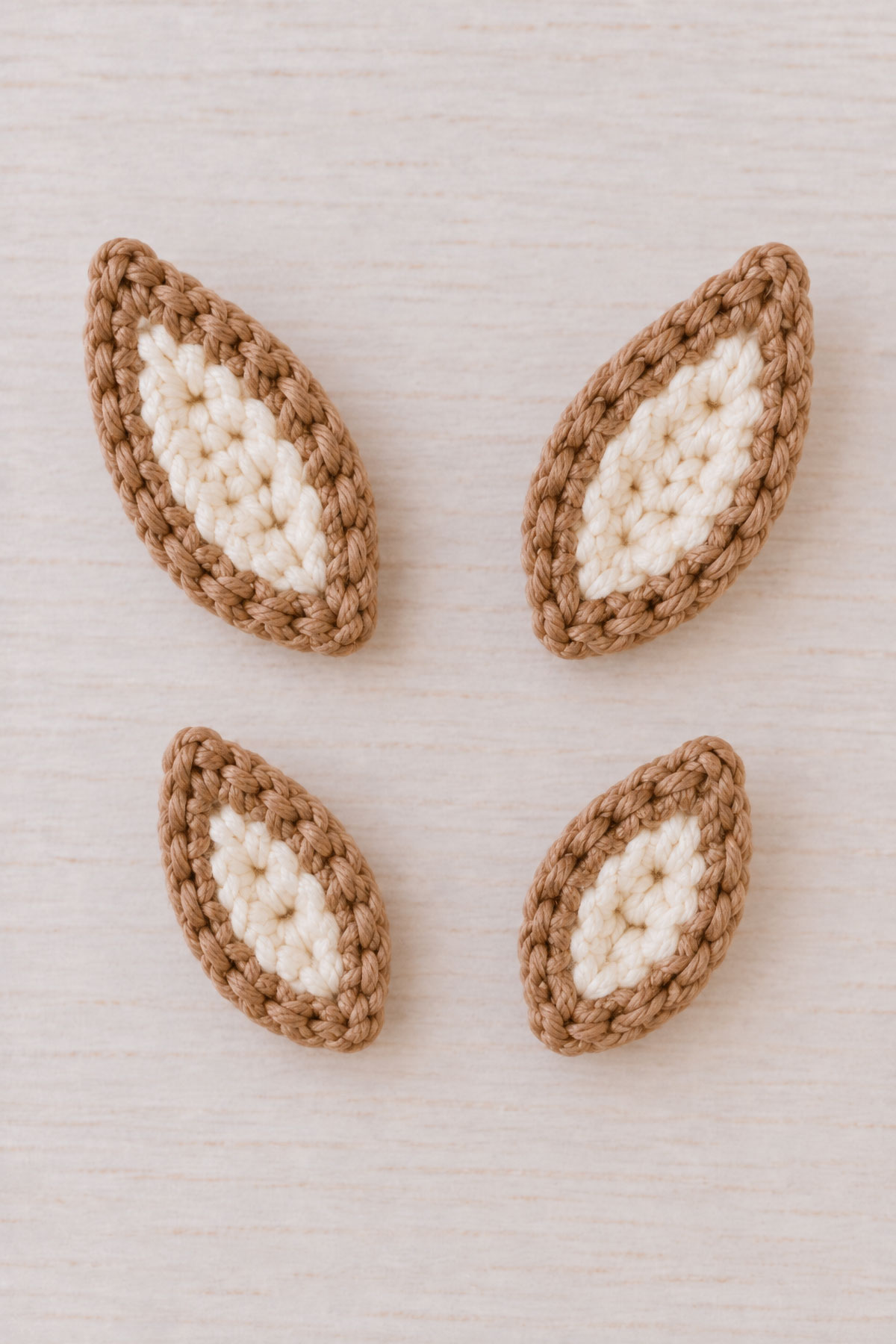 Crochet deer pattern layered tan and cream deer ears before assembly