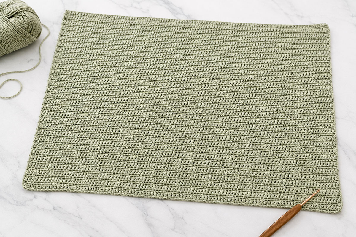 Plain sage half double crochet baby blanket base before the duck appliques and white border are added