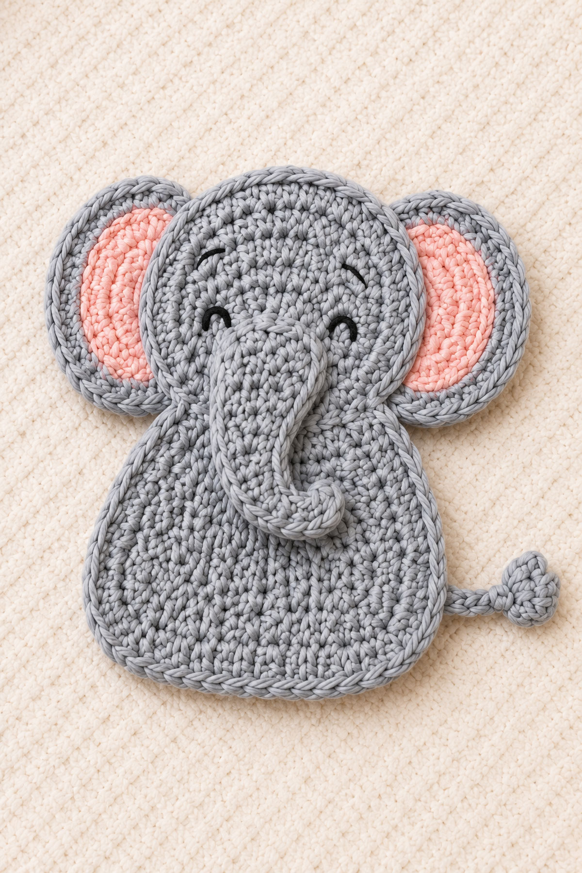 Gray crochet elephant applique with oversized ears curved trunk and embroidered face