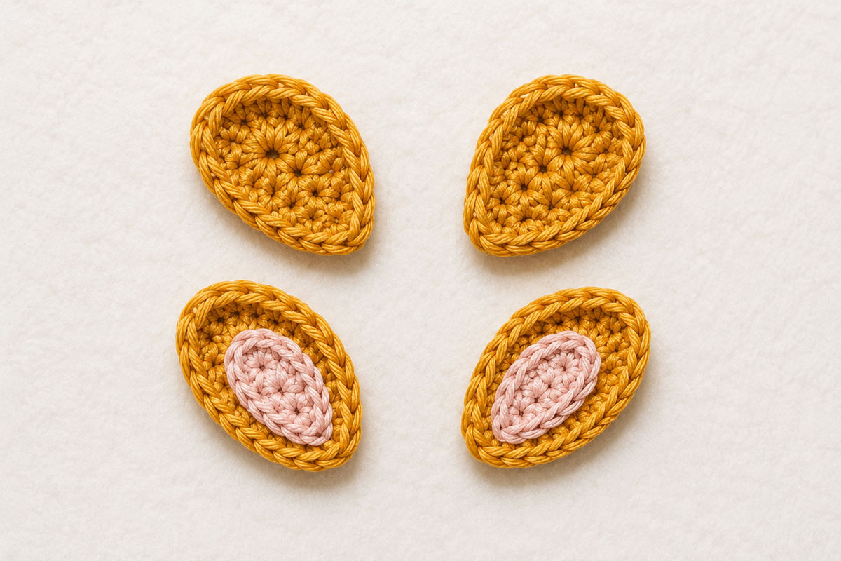 Crochet giraffe applique ears with pale pink inner ear patches ready for assembly
