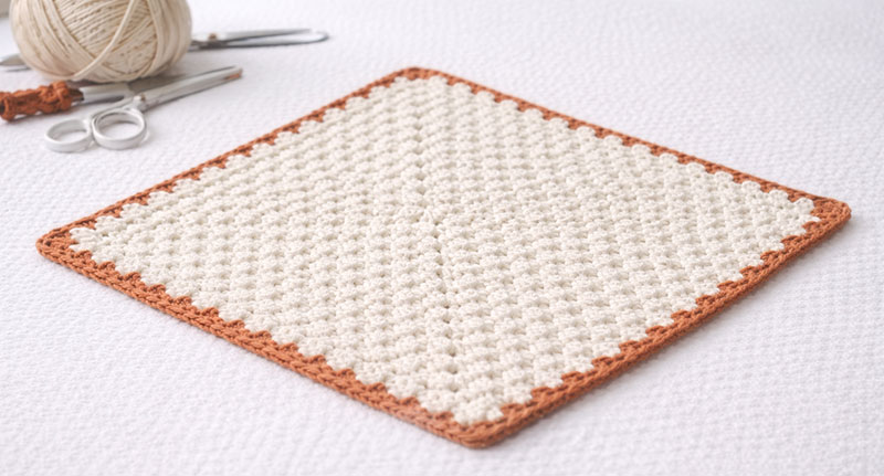 Crochet lovey blanket square worked from center showing corner increases and flat shape