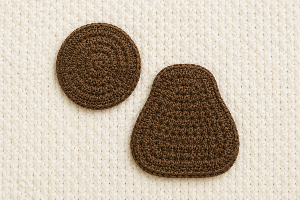 Separate pear-shaped brown crochet monkey body and round brown crochet head before assembly