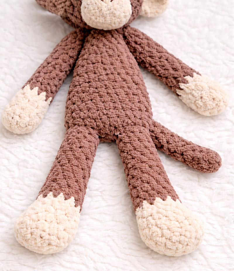 Crochet monkey with long arms and legs showing flexible structure