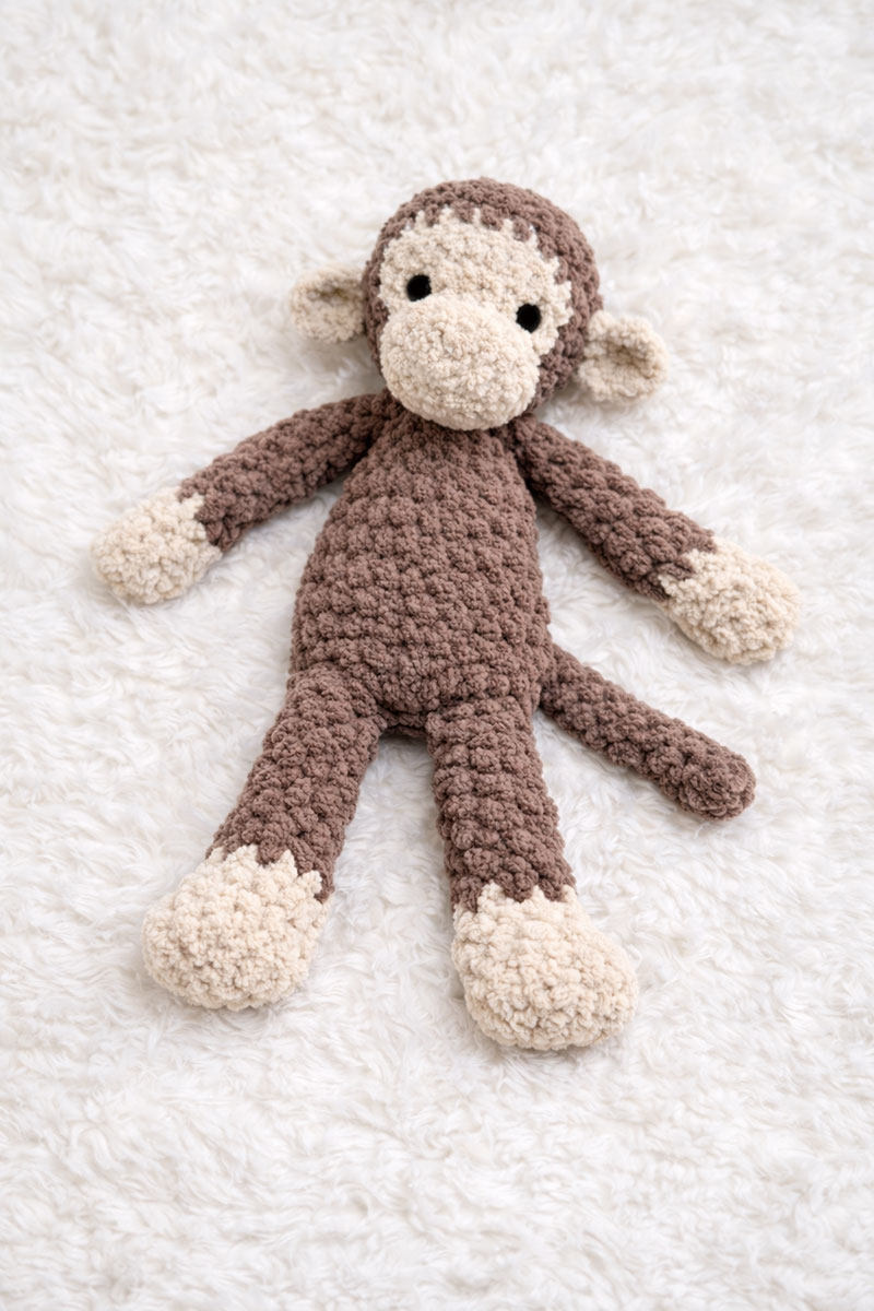 Soft crochet monkey lovey pattern made with plush yarn and floppy limbs for baby security and comfort