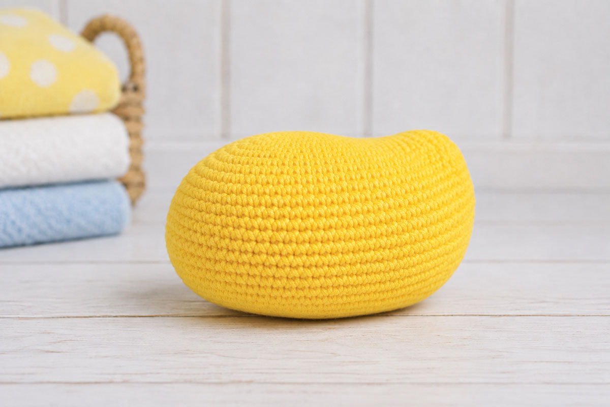 Yellow crochet rubber duck body worked as a low stuffed oval with a rounded front and slightly raised rear