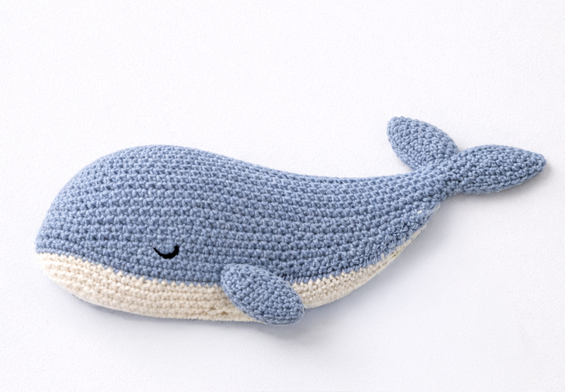 Flat crochet whale lovey pattern in blue gray and cream with a whale-shaped body