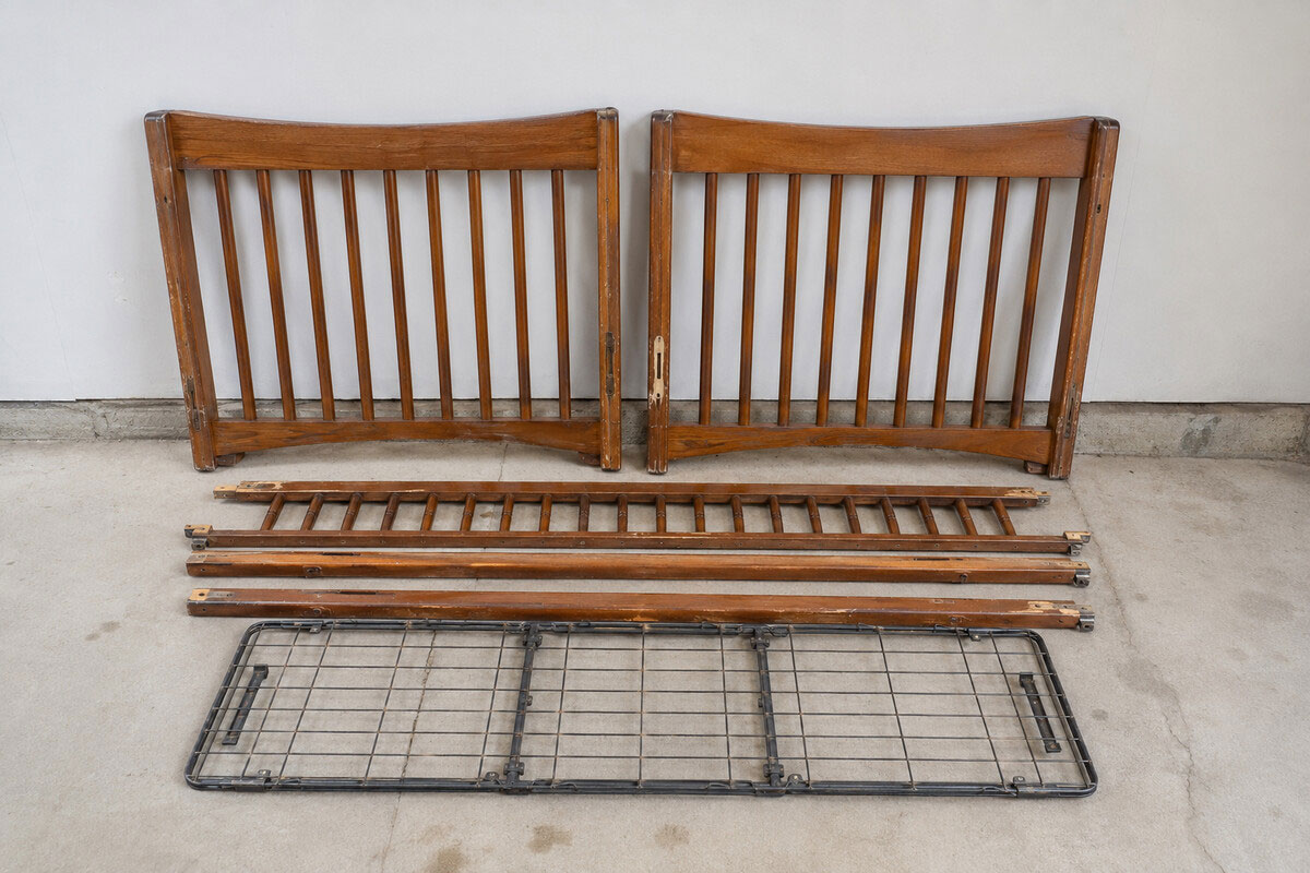 Dismantled old drop-side crib panels and hardware prepared for responsible disposal with no tools or repair activity shown