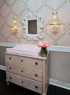 Carved wooden wainscoting trim chair rail in a pink and grey rococo nursery room