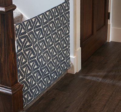 Homemade fabric baby gate made of heavy duty black and white canvas with a modern geometric pattern.
