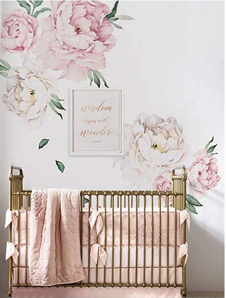Rose pink white and gold girl nursery room with a gold crib and large floral wall decals and artwork with gold lettering.