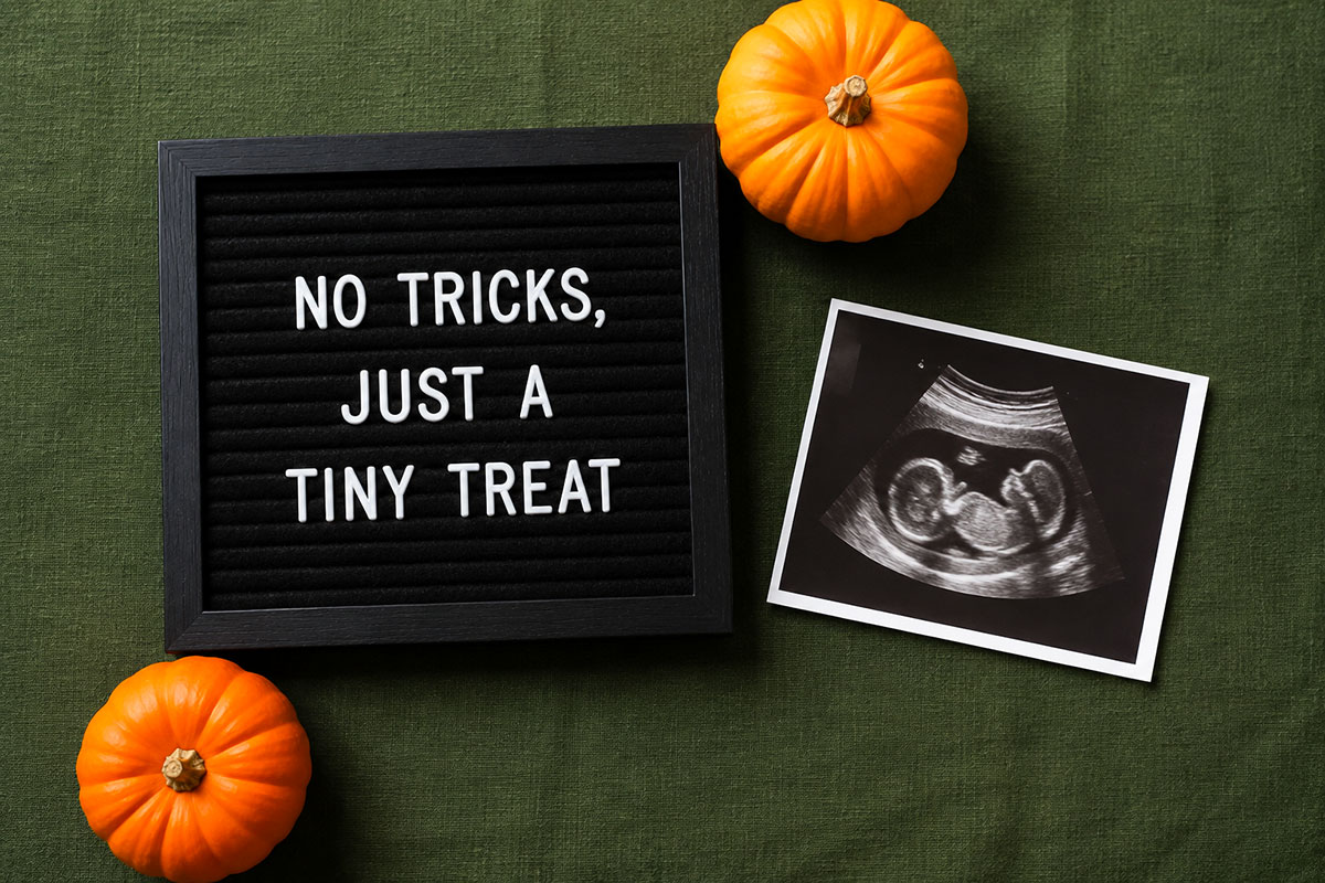 Halloween pregnancy announcement letter board beside an ultrasound photo and two small orange pumpkins