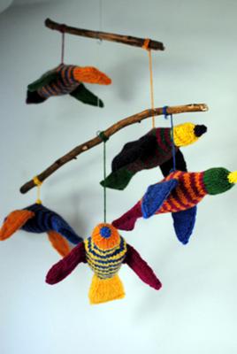Homemade DIY tropical birds baby crib mobile made with a tree branch hanger and knit birds