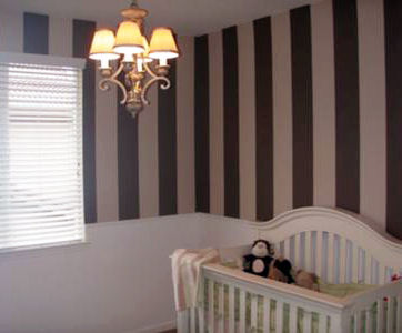 Baby girl nursery room with painted stripes and DIY wainscoting on the wall
