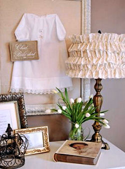 Vintage baby christening gown on display in a shadow box on a nursery wall