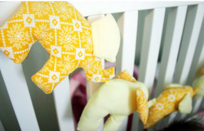 Bright yellow stuffed elephant bunting banner for a baby nursery