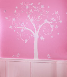 Large vinyl tree wall decal on the walls of a pink baby girl nursery with flowers and birds