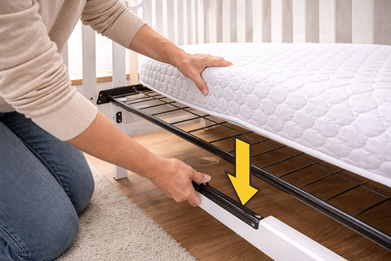 Crib with mattress set at a lower height position to reduce fall risk as babies grow