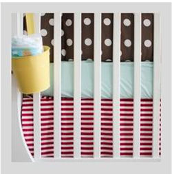Stripes and polka dots baby crib bedding in a shared nursery