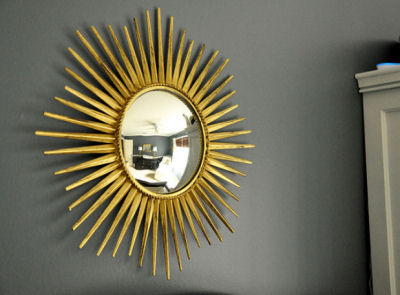 Gold metallic sunburst wall decoration in a navy blue and white baby boy nursery room
