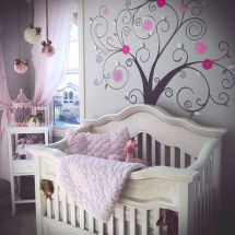 Pink and dark brown baby girl nursery design with pom poms ceiling mobile