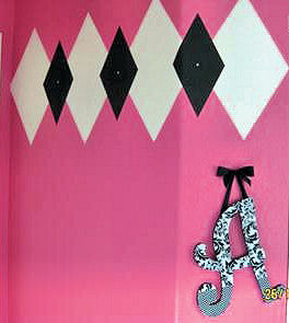 Pink, black and white argyle wall painting technique in a baby girl nursery room
