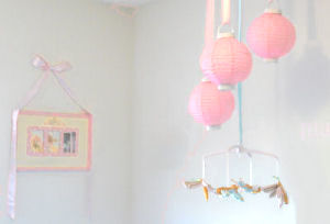 Nursery ceiling mobile made with pink paper lanterns and silk dragonflies hung with satin ribbons