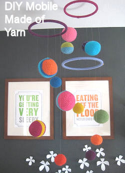 DIY homemade planets theme baby crib mobile for a nursery made of yarn in bright colors