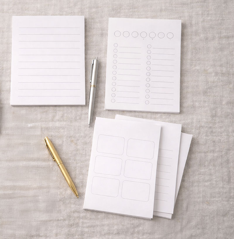 Flat lay of popular baby shower printable games with pens and envelopes arranged neatly