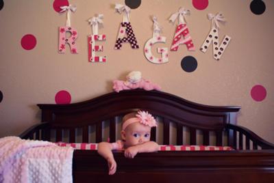 Our baby girl Reagan and her cozy crib!  The wooden letters that spell her name are framed by the pink and brown polka dots that decorate her nursery walls. 