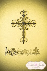 Black iron wall cross with ornate scrollwork and nursery wall decal