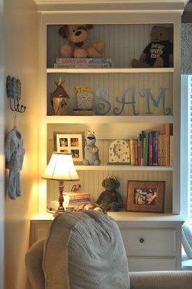 Built in shelves in baby boy nursery filled with gifts and items filled with memories from parents childhood