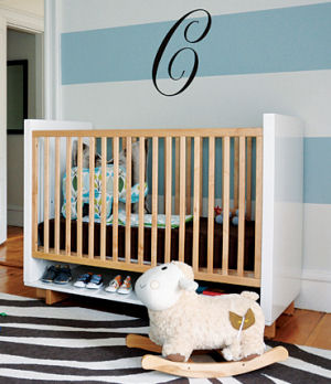 Modern white baby bed with natural wood rails in a blue and white baby boy nursery with a zebra rug