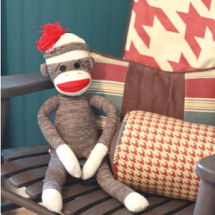 Baby sock monkey nursery theme with rust red and ivory bedding and painted beadboard wall in royal navy blue
