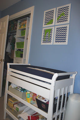 Modern navy blue white and lime green giraffe theme wall art over the changing table in a baby boy nursery